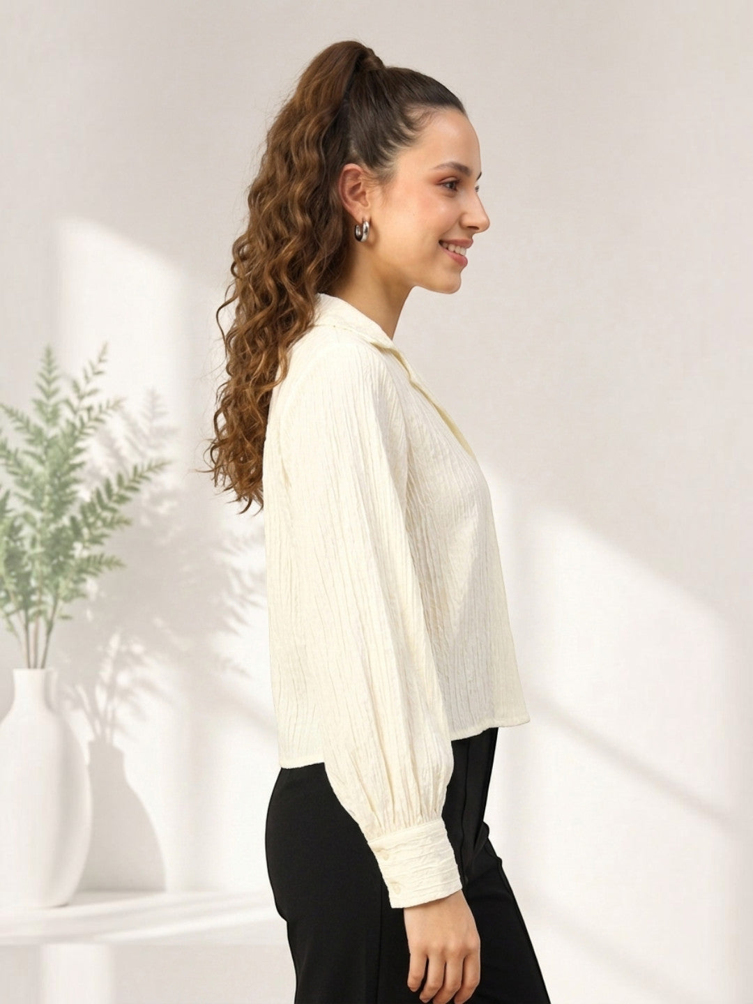 Woman in cream crinkle blouse with puff sleeves, black pants, plus size fashion