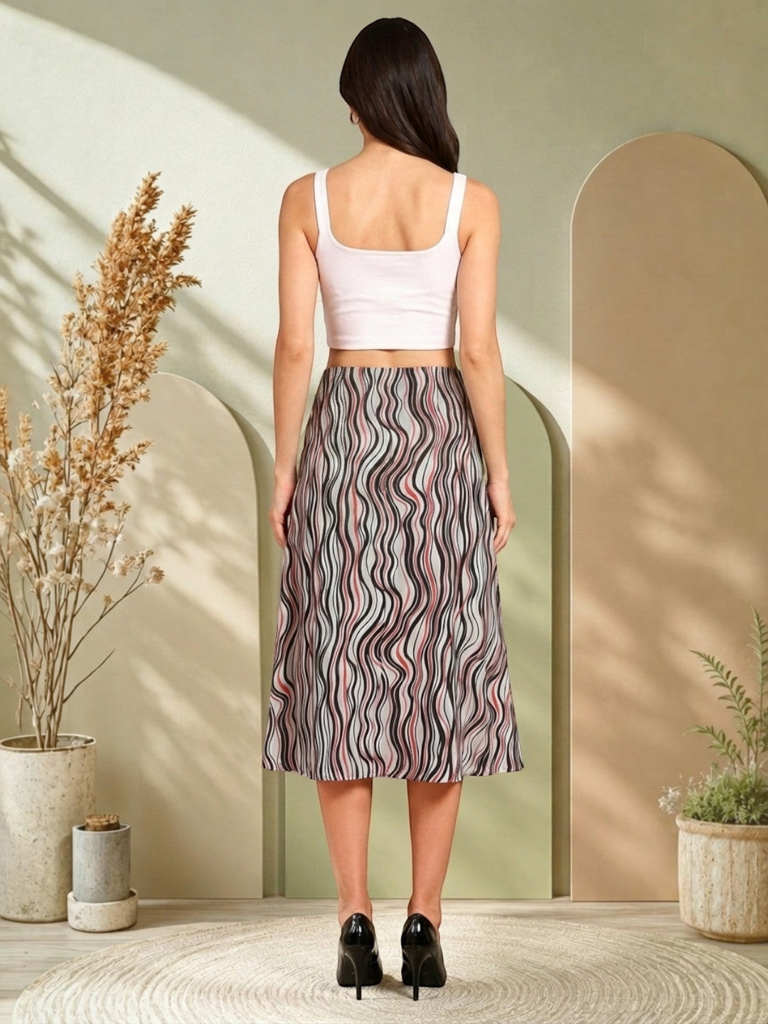 Woman wearing wavy striped midi skirt with white crop top, black heels, stylish plus size fashion