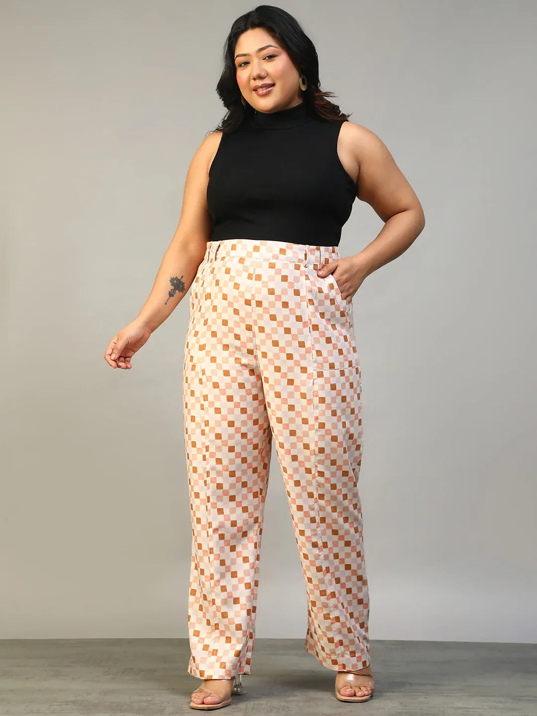 A person wearing a pair of wide-leg pants with a checkered pattern in shades of pink and white.