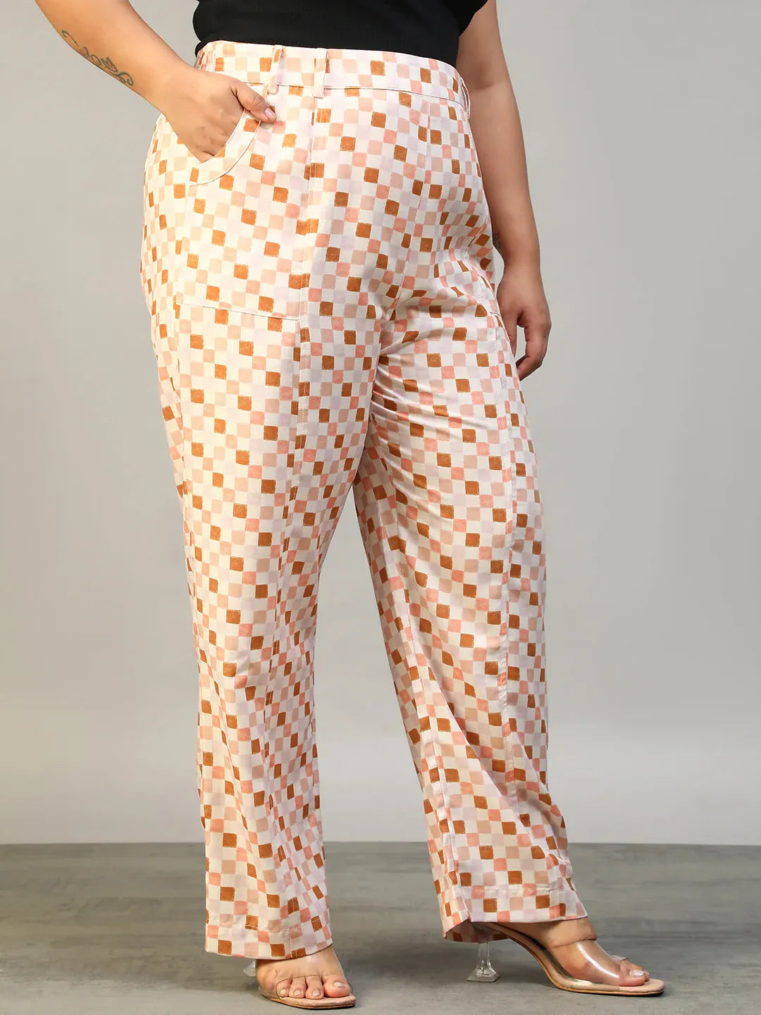 A person wearing a pair of wide-leg pants with a checkered pattern in shades of pink and white.