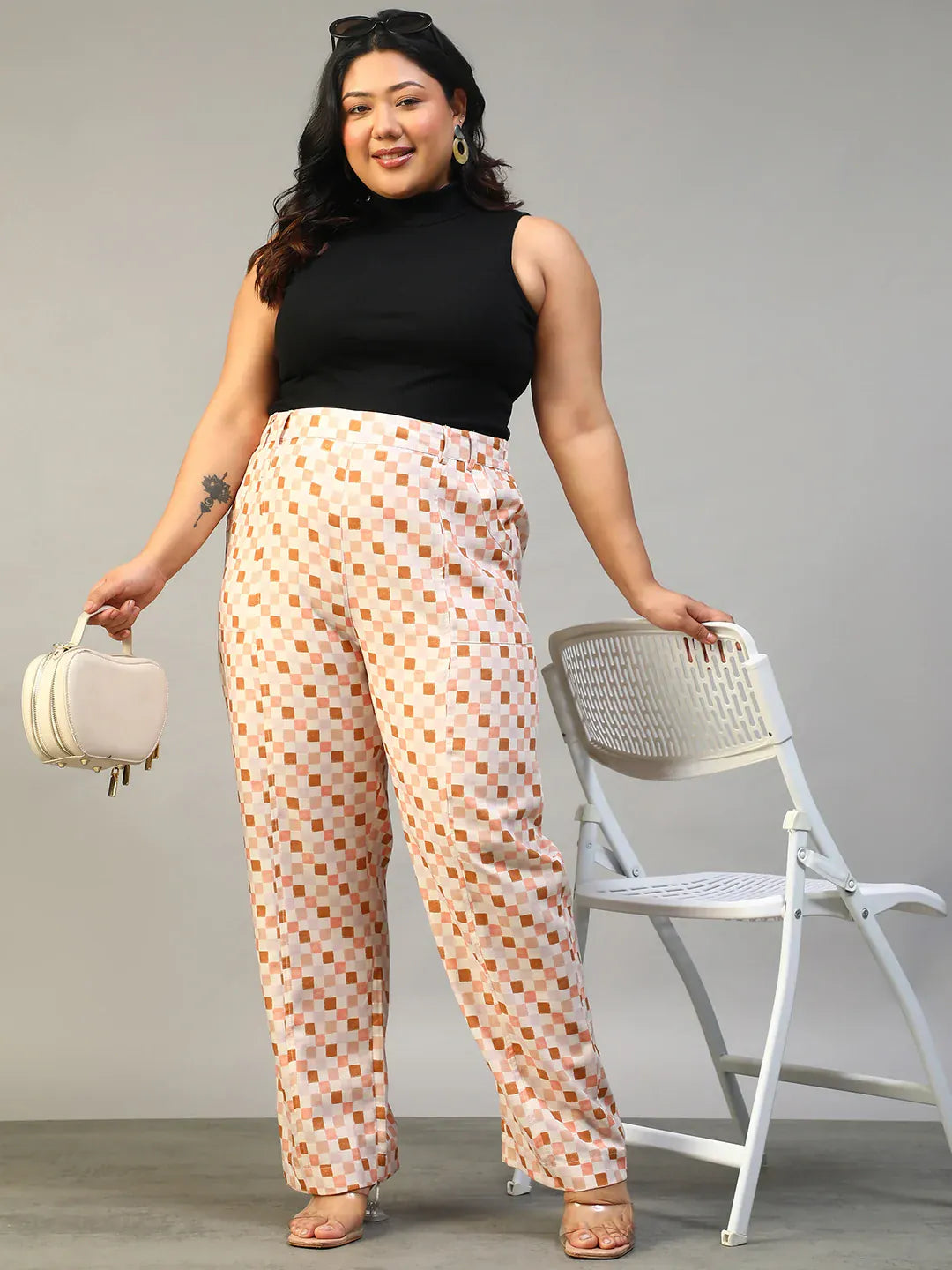 A person wearing a pair of wide-leg pants with a checkered pattern in shades of pink and white.