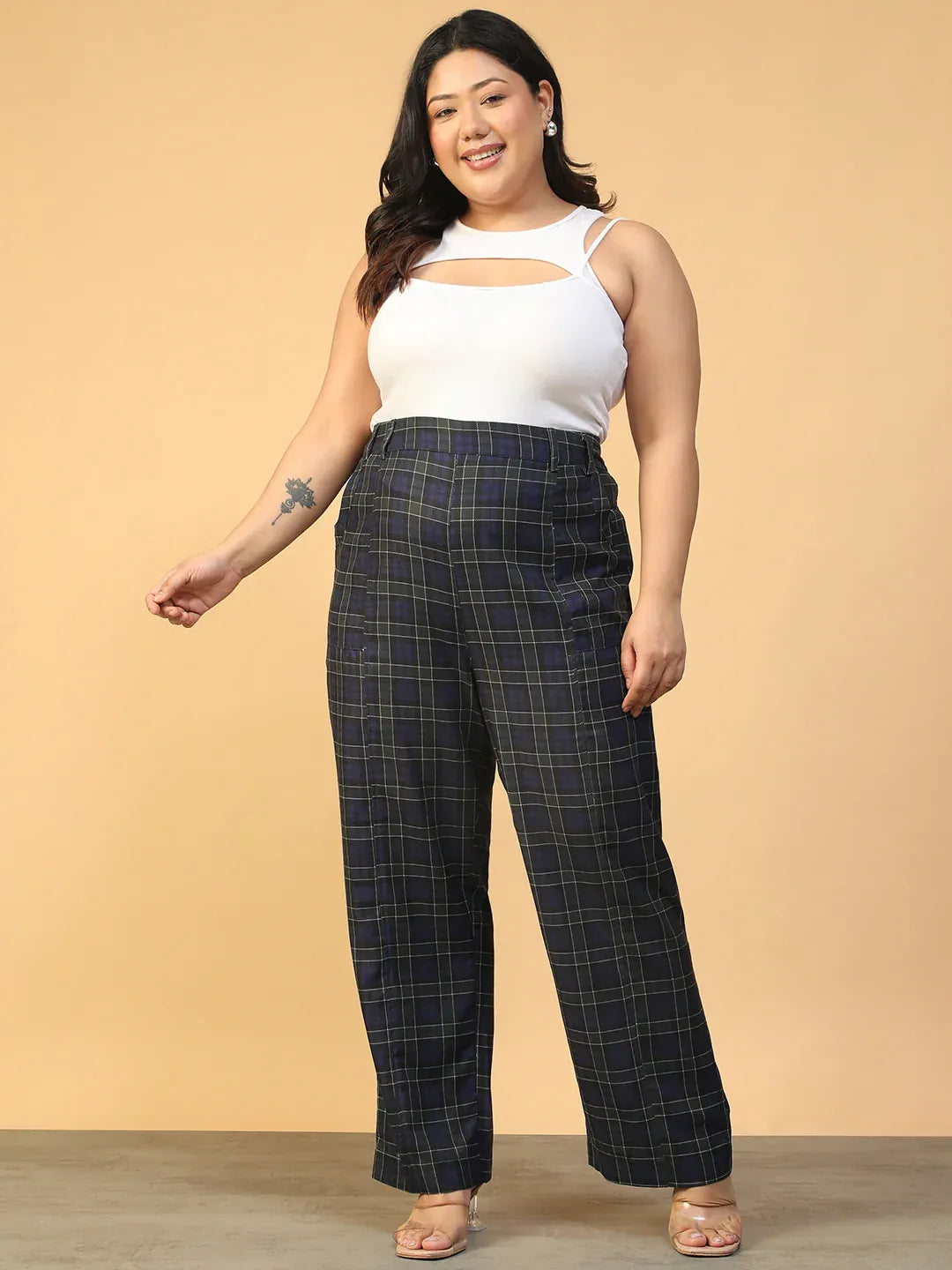 A person wearing a pair of black and green plaid pants.