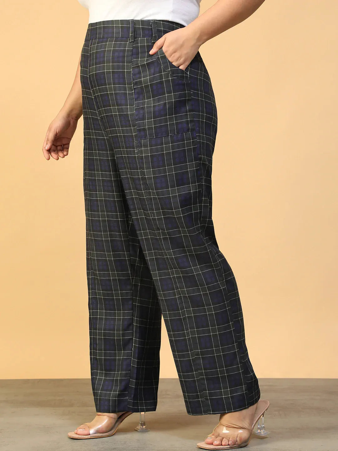 A person wearing a pair of black and green plaid pants.