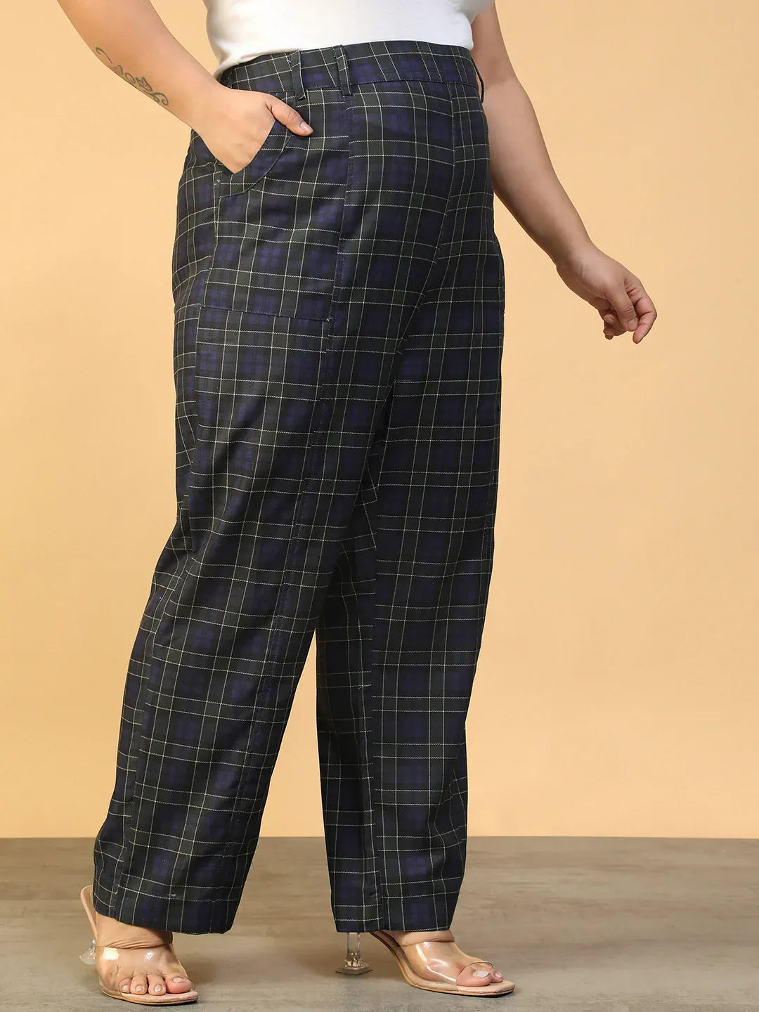 A person wearing a pair of black and green plaid pants.