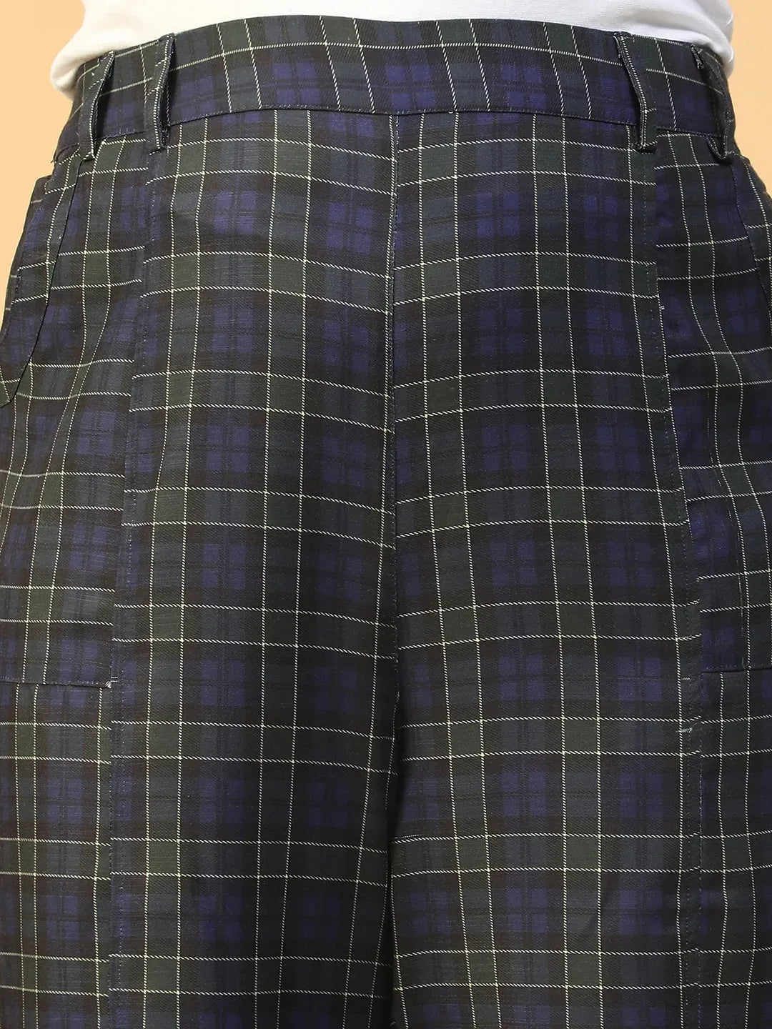 A person wearing a pair of black and green plaid pants.