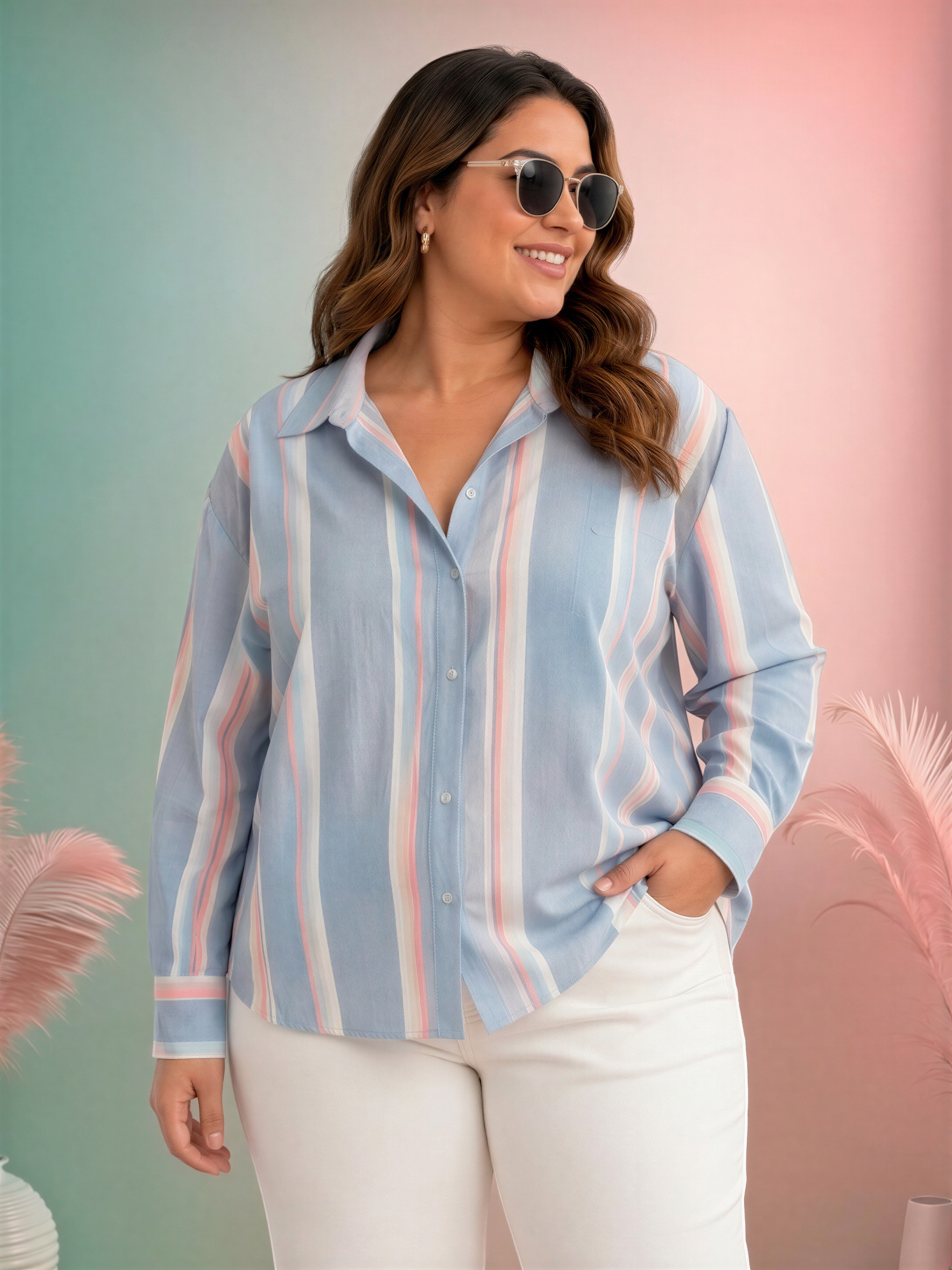 A woman wearing a striped shirt and sunglasses stands in front of a pink and green background.